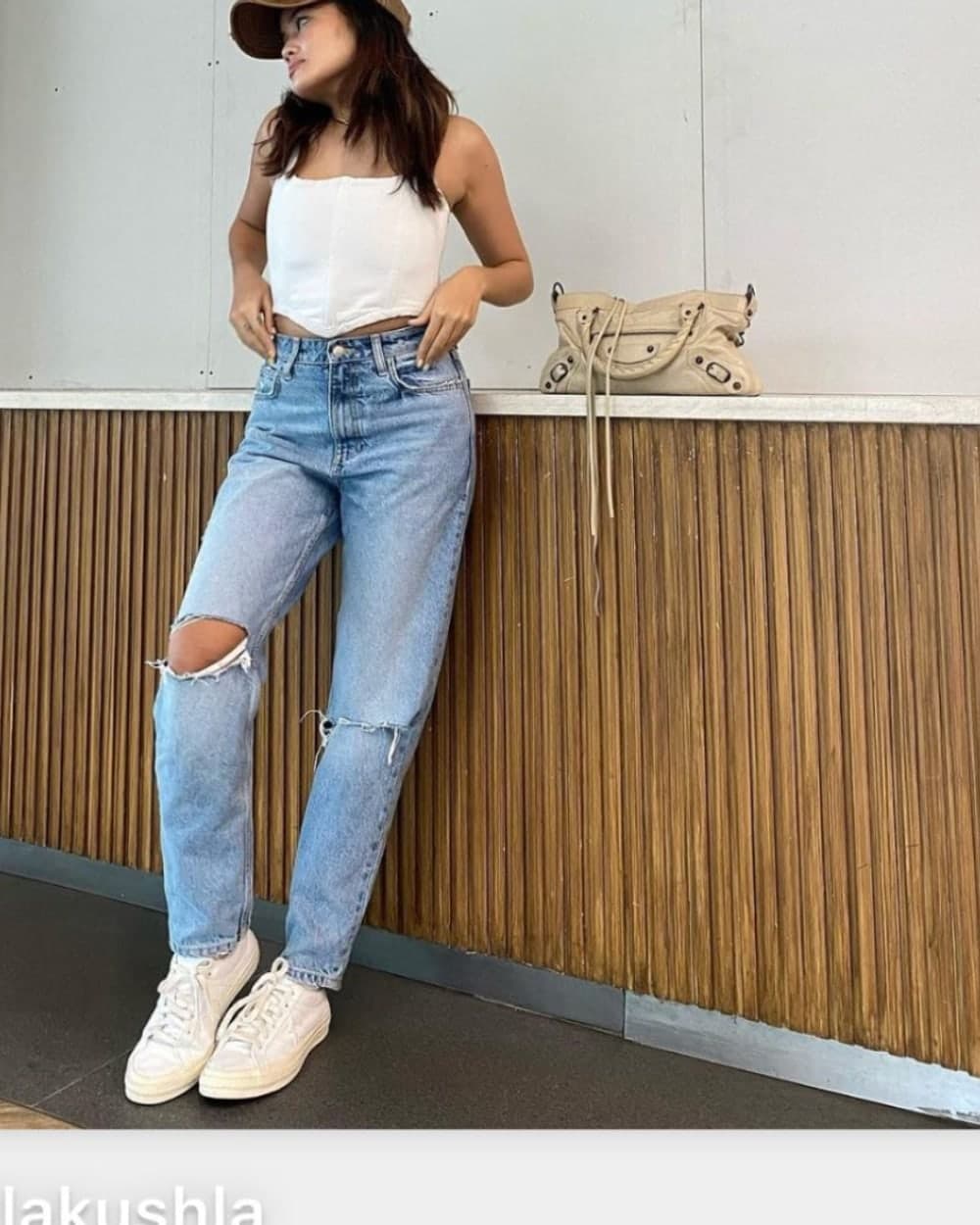 A customer in the white doce corduroy corset top with light-wash jeans